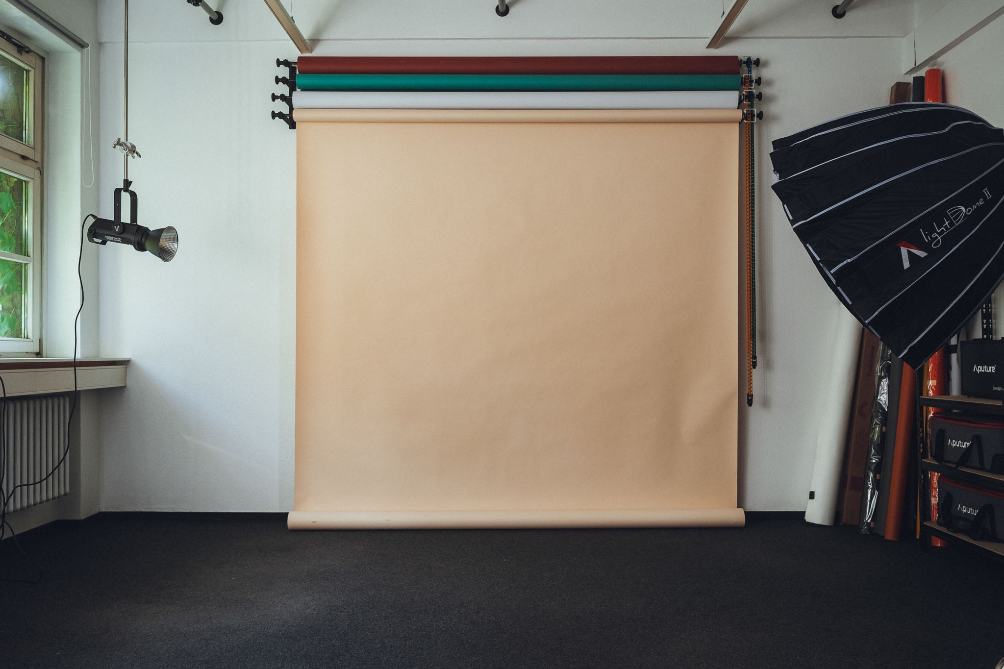 Ausgestattetes Fotostudio mit Backdrops, Lichtern und natürlichem Licht und verschiedenen Fotohintergründen.